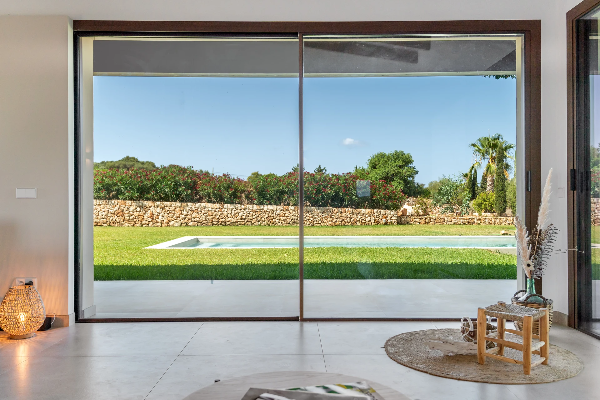 Vista interior a través de puertas correderas de cristal hacia la piscina — Finca en Ses Salines, Mallorca
